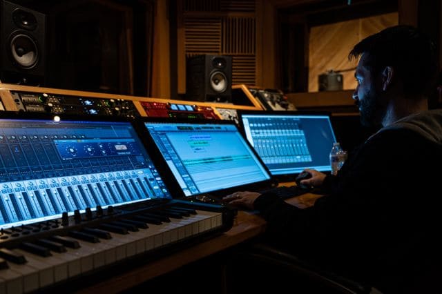Professionnel travaillant sur une composition musicale dans un studio d’enregistrement.