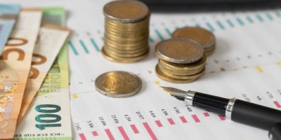 Piles de pièces et billets symbolisant les aides financières pour les entreprises du Grand Est en 2026 PLF 2026 innovation : nouveaux dispositifs fiscaux JEI, CII-IA et transition écologique