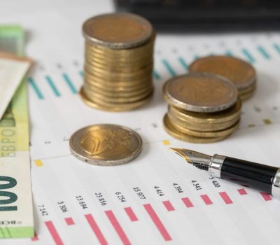 Piles de pièces et billets symbolisant les aides financières pour les entreprises du Grand Est en 2026 PLF 2026 innovation : nouveaux dispositifs fiscaux JEI, CII-IA et transition écologique