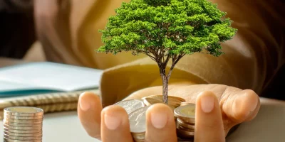 Image d'un homme au travail montrant sa pomme où pousse un arbre dont la racine est représentée par des pièces de monnaie. À côté, d'autres pièces de monnaie. Cette image représente les aides régionales en Île-de-France, notamment les dispositifs Innov'up, PM'up et TP'up.