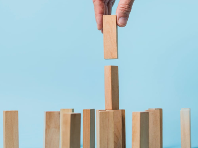 figurines en bois de petits hommes d'une famille et d'un sac plein avec l'inscription subvention sur fond bleu. Cette image a pour le but de représenter les subventions pme en France en 2025