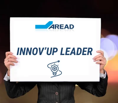 Une personne tenant une feuille blanche sur laquelle figurent les mots « Innov'up leader » et le logo d'Aread.
